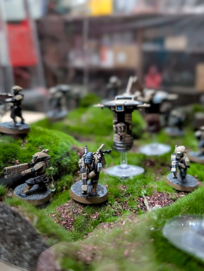 Partida de Warhammer con miniaturas pintadas sobre una mesa de juego